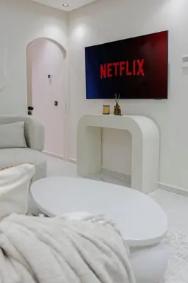 a white living room with a netflix sign on the wall at Premium Hospitality - Hivernage Marrakech in Marrakech