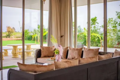a living room with a large couch and windows at Golfside Villas in Marrakech