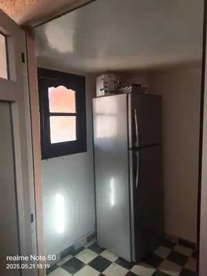 a kitchen with a refrigerator and a window at La maison de Hamza in Marrakech