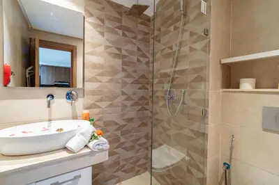 a bathroom with a sink and a shower at Appartement Moderne Centre Gueliz Sunny Pool PS4 & Wi-Fi in Marrakech