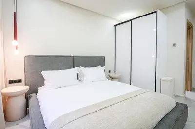 a bedroom with a large bed with white sheets at Nova Collection - Hivernage Marrakech in Marrakech