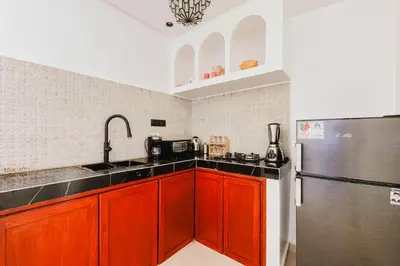 a kitchen with red cabinets and a stainless steel refrigerator at Maison Joudia in Marrakech