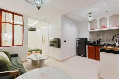 a kitchen and living room with a couch and a table at Maison Joudia in Marrakech