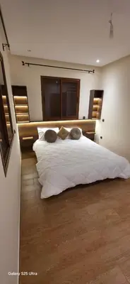 a bedroom with a large bed with white sheets at Nizar 1 in Marrakech