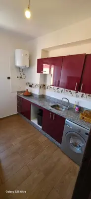 a kitchen with red cabinets and a washing machine at Nizar 1 in Marrakech