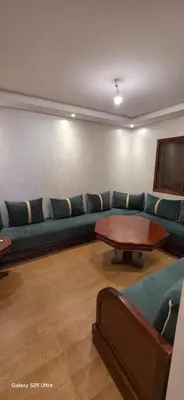 a living room with a blue couch and a table at Nizar 1 in Marrakech