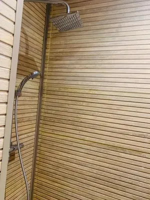 a shower in a bathroom with a wooden wall at 1 bedroom apartment Miramas 2, gueliz in Marrakech