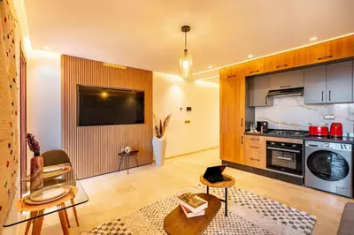 a living room with a kitchen with a stove and a table at Ultra Central Gueliz 1 bedroom in Marrakech