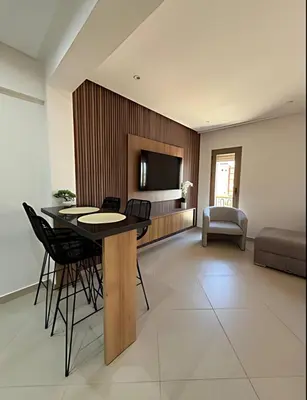 a living room with a table and chairs and a television at Central Gueliz Apartment Walk to Train Station in Marrakech