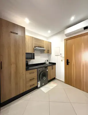 a kitchen with wooden cabinets and a washer and dryer at Central Gueliz Apartment Walk to Train Station in Marrakech