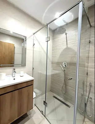 a bathroom with a glass shower and a sink at Central Gueliz Apartment Walk to Train Station in Marrakech