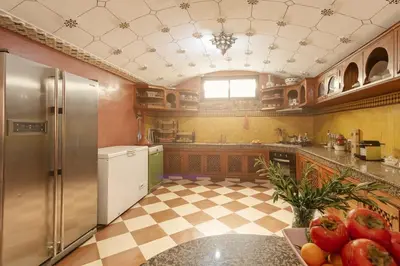 a kitchen with a refrigerator and a checkered floor at Riad Safran - Private Cook & Indoor Pool Gem in Marrakech