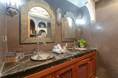 a bathroom with two sinks and two mirrors at Riad Safran - Private Cook & Indoor Pool Gem in Marrakech