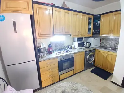 a kitchen with wooden cabinets and a white refrigerator at Aux Majorelles-Gueliz in Marrakech