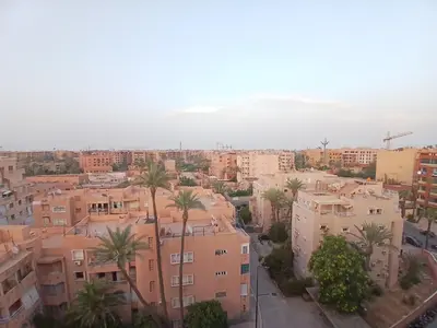 an aerial view of a city with palm trees and buildings at Aux Majorelles-Gueliz in Marrakech