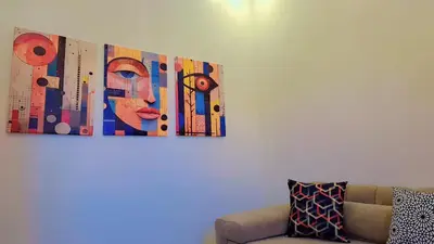 a painting of a woman on a wall next to a couch at Appartement Aéroport Suite Marrakech-M9 in Marrakech