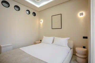 a bedroom with a white bed and four clocks on the wall at The Crown Edition - Hivernage Marrakech in Marrakech
