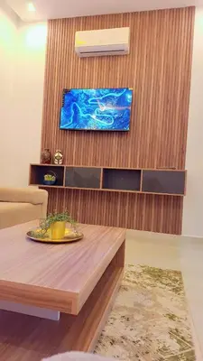 a living room with a table and a tv at Appartement Aéroport Stay Marrakech-M9 in Marrakech