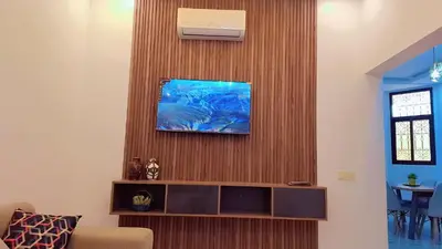 a living room with a tv on a wooden wall at Appartement Aéroport Stay Marrakech-M9 in Marrakech