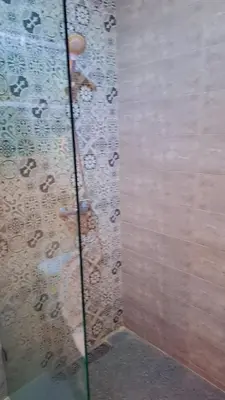a shower with a glass door with raindrops on it at Appartement Aéroport Sunset Marrakech in Marrakech
