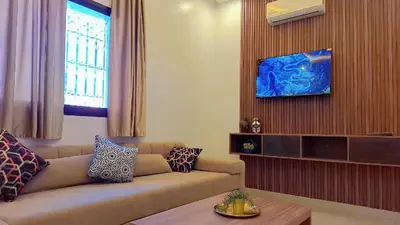 a living room with a couch and a tv at Appartement Aéroport Sunset Marrakech in Marrakech