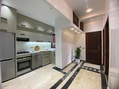 a kitchen with stainless steel appliances and a black door at Elegance and comfort in the heart of Marrakech in Marrakech