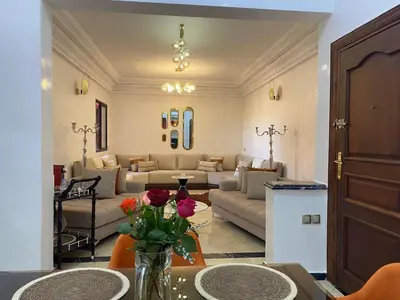 a living room with couches and a table with flowers at Elegance and comfort in the heart of Marrakech in Marrakech