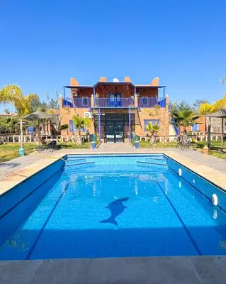 a large swimming pool in front of a house at Charming Family Villa with Private Pool & Garden - Near Marrakech in Sraïri