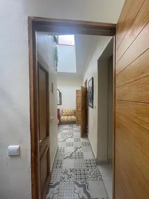 a hallway with a door and a tile floor at Dar darkoum in Marrakech