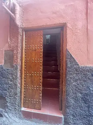 a stairway with a wooden door in a building at Dar darkoum in Marrakech