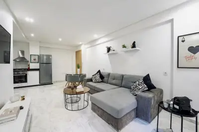 a living room with a couch and a kitchen at Terrace & Fast Wi-Fi - Stylish city center flat - Gueliz in Marrakech