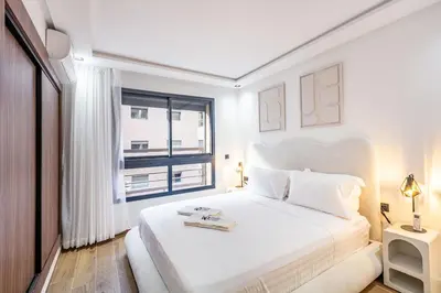 a white bedroom with a large bed and a window at Modern apartment close to M Avenue & Menara Mall in Marrakech