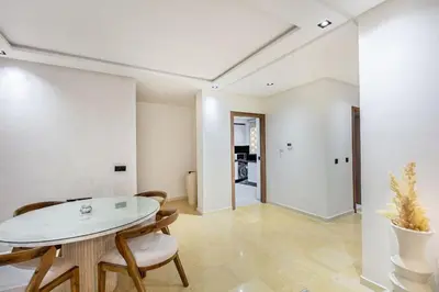 a white dining room with a table and chairs at Modern apartment close to M Avenue & Menara Mall in Marrakech