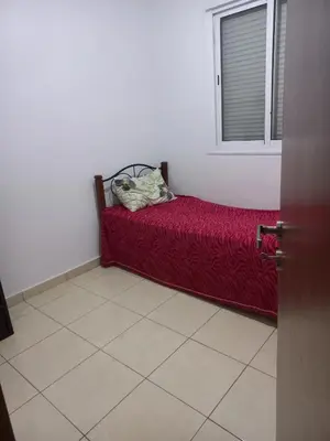 a bed in a room with a red blanket and a window at Marrakech in Marrakech