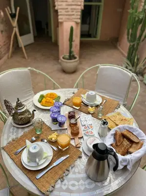 a table with breakfast food on top of it at Riad Birdy, Charmant et privatif, Piscine, Rooftop, 6 suites, 2 salons, Wifi in Marrakech