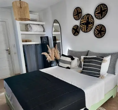 a bedroom with a bed with black and white pillows at Riad Birdy, Charmant et privatif, Piscine, Rooftop, 6 suites, 2 salons, Wifi in Marrakech