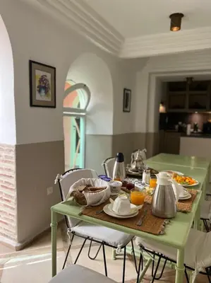 a green table with food on it in a kitchen at Riad Birdy, Charmant et privatif, Piscine, Rooftop, 6 suites, 2 salons, Wifi in Marrakech