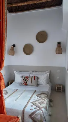 a bedroom with a bed with white sheets and pillows at Riad Birdy, Charmant et privatif, Piscine, Rooftop, 6 suites, 2 salons, Wifi in Marrakech