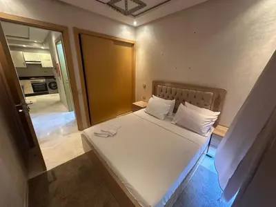 a small bedroom with a bed with white sheets and pillows at Karam eddin in Marrakech