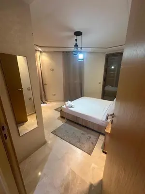 a bedroom with a white bed and a mirror at Karam eddin in Marrakech