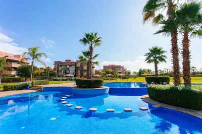 a pool at a resort with palm trees at Saphire Luxury - Marrakech- Prestigia in Marrakech