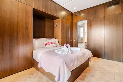 a bedroom with a large bed with wooden walls at appartement avec piscine et charme marocain in Marrakech