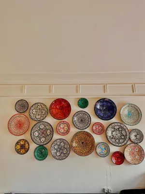 a bunch of colorful plates hanging on a wall at appartement avec piscine et charme marocain in Marrakech