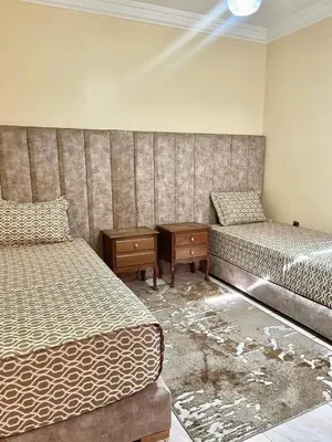 a room with two beds and a table and a bedskirts at Mobarak immo Appt 10 in Marrakech