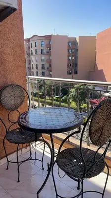a table and chairs on a balcony with a view of a city at Mobarak immo Appt 10 in Marrakech