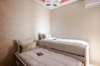 a bedroom with two beds and a couch in it at Moroccan Comfort & Charm - 10 min from Guéliz in Marrakech