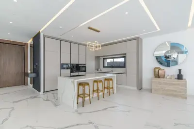 a kitchen with white marble flooring and a bar with stools at Villa Sofya - Roche Bobois Design & HD Wifi in Marrakech