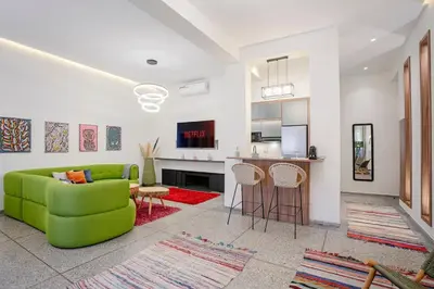 a living room with a green couch and a kitchen at 2BR Art Deco Loft - Central Gueliz Marrakech in Marrakech