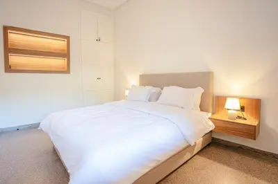 a bedroom with a large white bed with two lamps at 2BR Art Deco Loft - Central Gueliz Marrakech in Marrakech