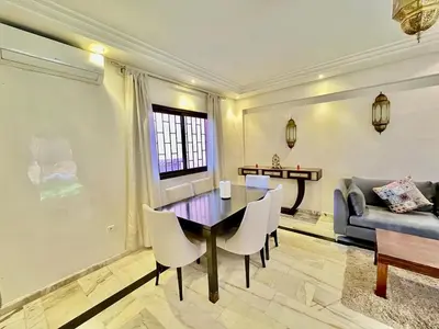 a dining room with a table and chairs and a couch at Perfect stay in Guéliz Book now! in Marrakech
